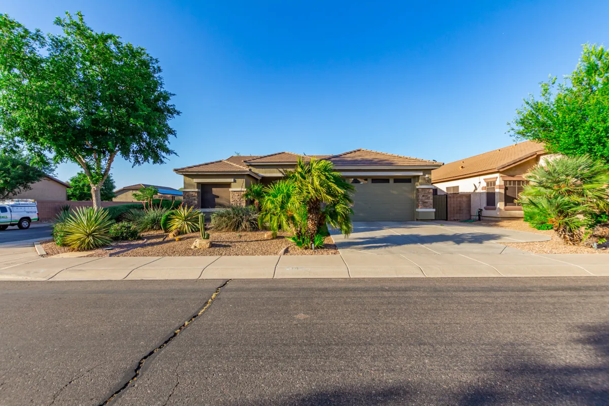 This photo shows the home's modern facade with a landscaped front yard and prominent palm trees. The inviting exterior suggests a tranquil neighborhood setting, suitable for family activities and easy daily routines.